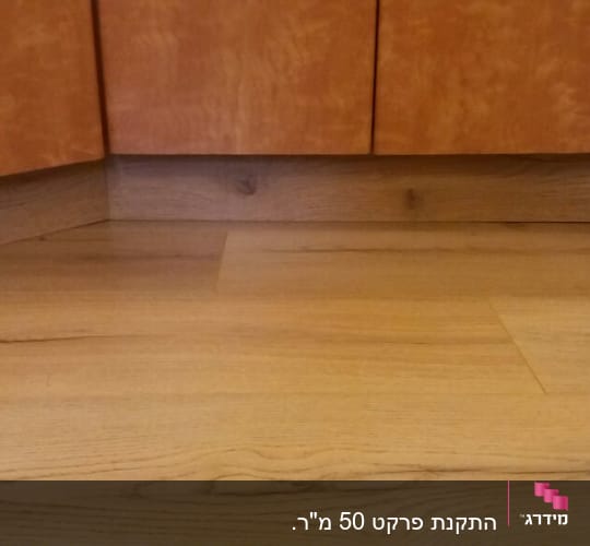 רצפת פרקט עץ בהירה מתחת לארונות מטבח